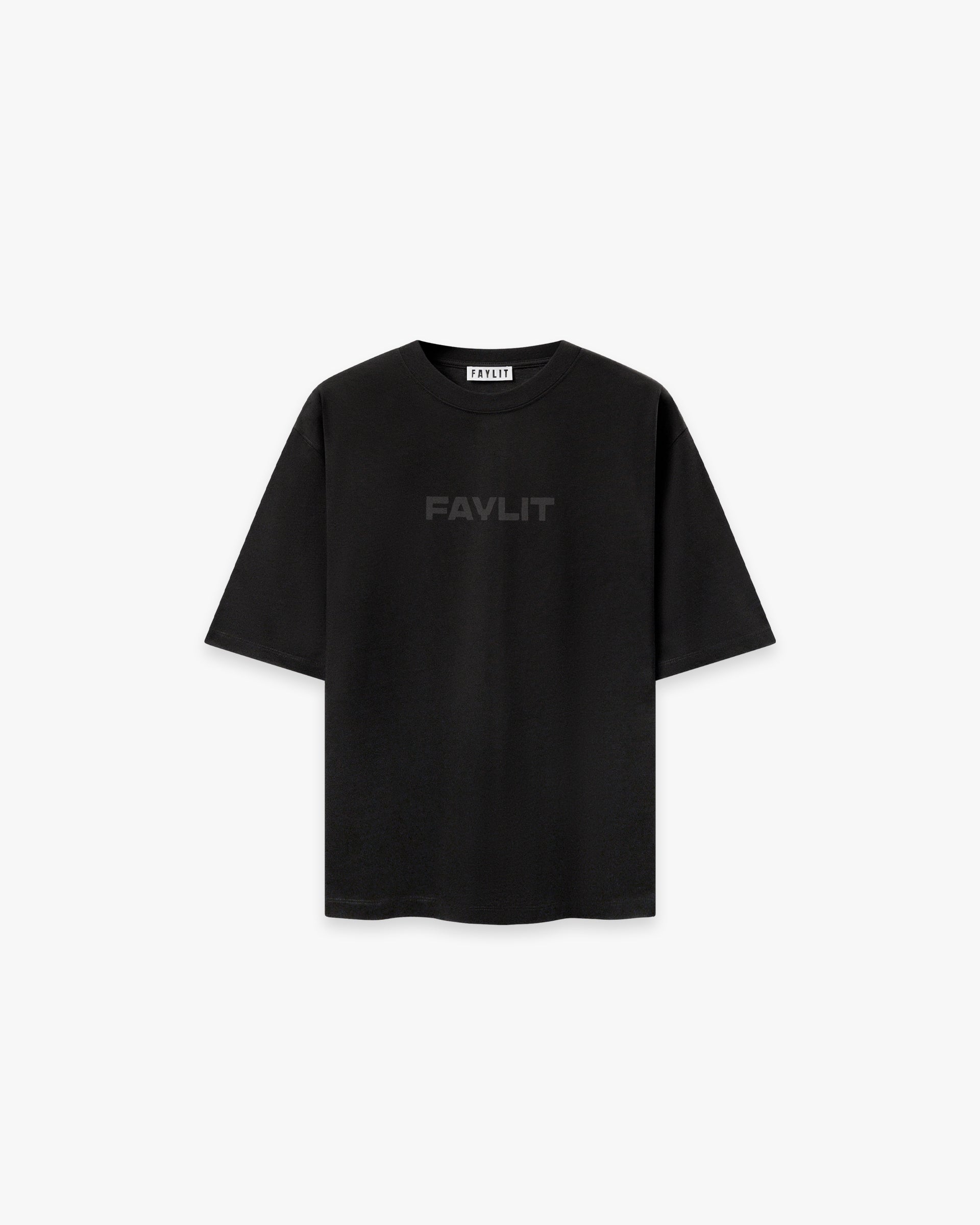 Blackout Kabartma Logo Siyah Oversize Tişört Siyah oversize tişörtün ön yüzünün düz çekim ürün fotoğrafı. Tişörtün göğüs kısmında, siyah üzerine siyah, kabartmalı ve parlak bir teknikle "FAYLIT" yazısı basılmıştır. Bu tonal baskı, tişörte minimalist ve şık bir görünüm kazandırır. Yaka içindeki marka etiketi görülebilir. -  Faylit