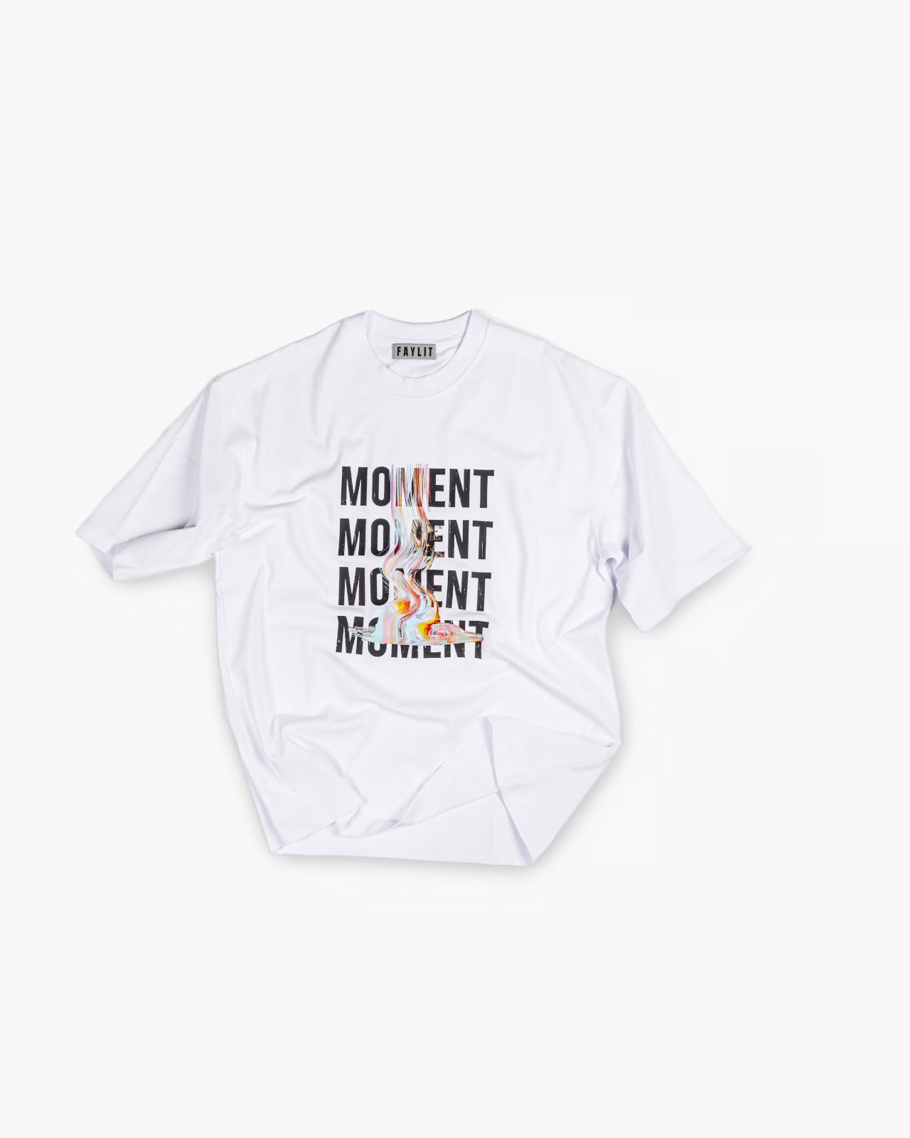 FAYLIT beyaz oversize tişört, ön kısmında tekrarlanan "MOMENT" yazısı ve üzerinde renkli, soyut bir figür içeren grafik baskı, unisex ve boxy fit kesim, modern stil.