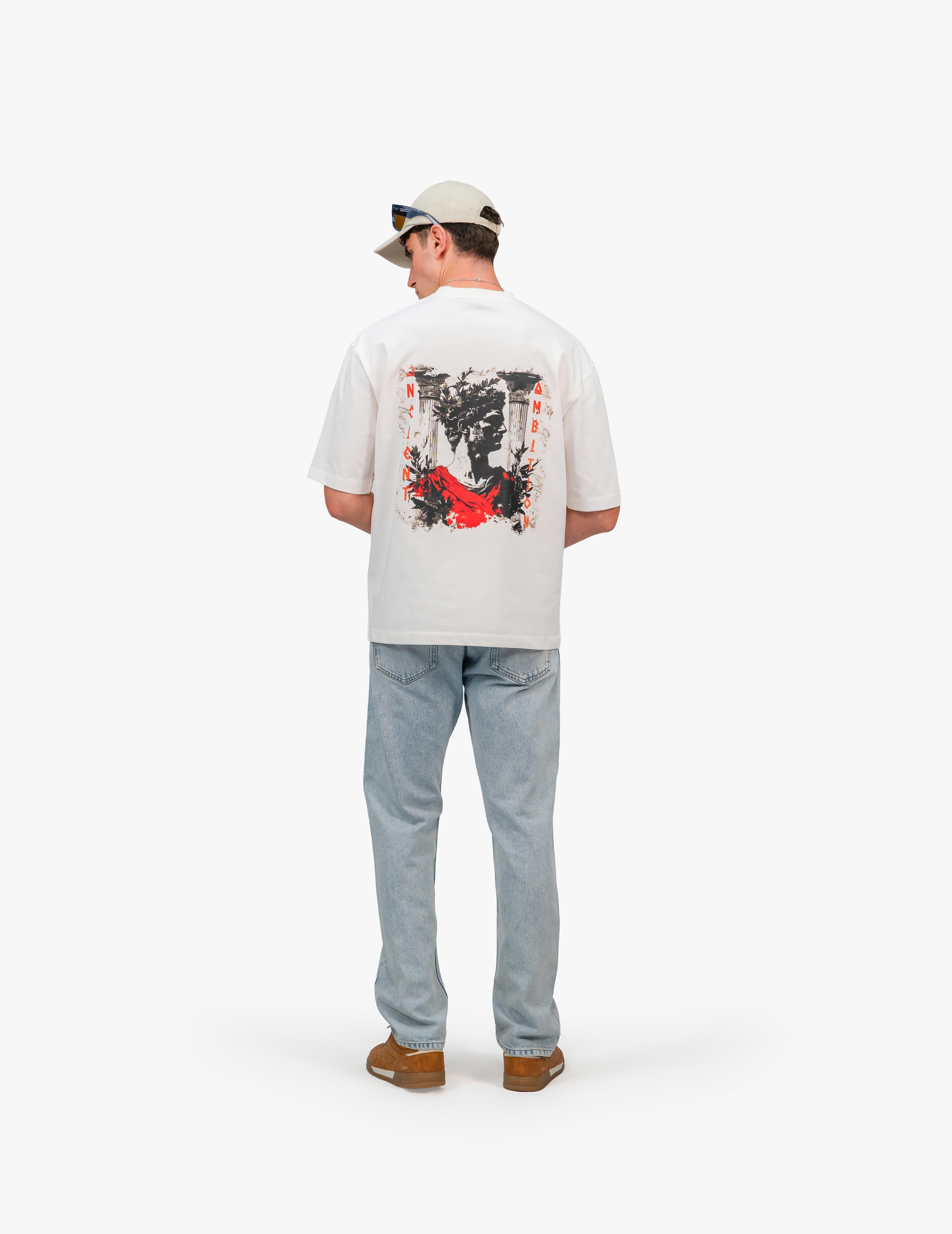 Ancient Ambition Vintage Off White Oversize Tişört, Beyaz bir stüdyo fonunun önünde, arkası dönük ve hafifçe sola dönük bir şekilde duran, kısa kahverengi saçlı ve bej renkli bir şapka takan bir erkek. Üzerinde sırtında siyah, beyaz ve kırmızı renklerde soyut bir grafik baskı bulunan beyaz, geniş kesim bir tişört ve açık mavi, bol kesim bir kot pantolon giyiyor. Ayaklarında kahverengi ayakkabılar bulunuyor. -  Faylit