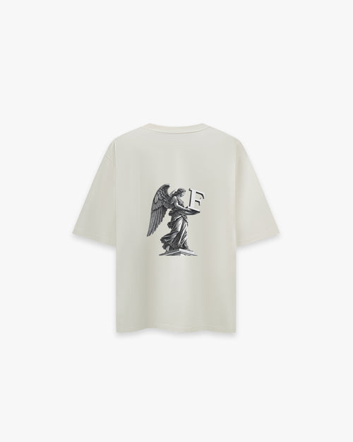 Angel Off White Oversize Tişört- Krem rengi (Off White) oversize tişörtün sırt yüzeyinin düz çekim ürün fotoğrafı. Tişörtün sırtında, siyah-beyaz tonlarda, büyük ve detaylı bir baskı bulunmaktadır. Baskı, bir kaide üzerinde duran kanatlı bir melek heykelini ve bu heykelin kollarında tuttuğu büyük, 3 boyutlu bir 'F' harfini tasvir ediyor. -  Faylit