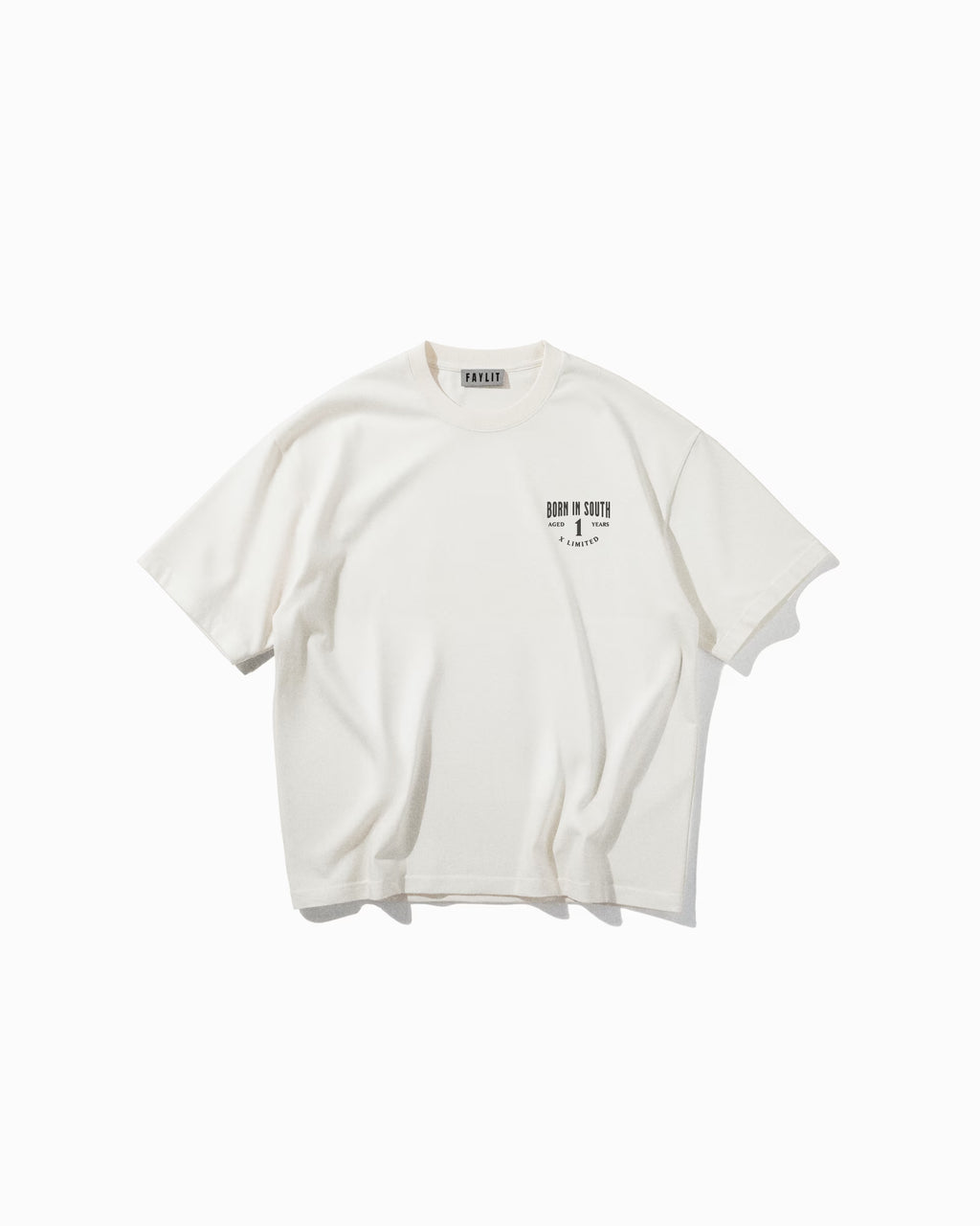 Culture Off White Oversize Tişört Kırık beyaz (off-white) oversize tişörtün ön yüzünün düz çekim ürün fotoğrafı. Tişörtün sol göğüs kısmında, siyah renkte küçük bir logo baskısı yer alıyor. Baskıda, eskitme efektli ve kalın bir fontla "FAYLIT" yazmaktadır. Yaka içindeki marka etiketi de görülebilmektedir.