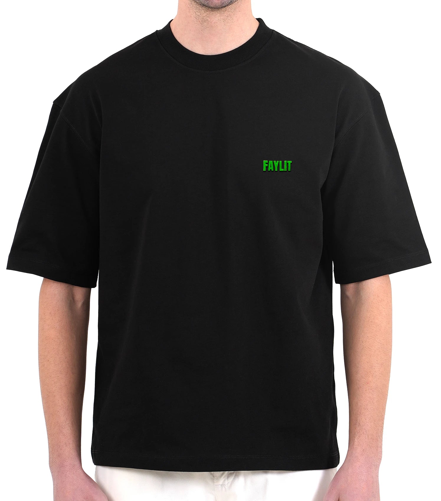 FDNA_01 Oversize Tişört - Siyah oversize tişört giyen erkek mankenin göğüs bölgesinin yakın çekimi. Tişörtün sol göğsünde, parlak neon yeşili renginde minimalist "FAYLIT" logosu bulunmaktadır. Tişörtün bol ve dökümlü kesimi modelin üzerinde görülmektedir. -  Faylit