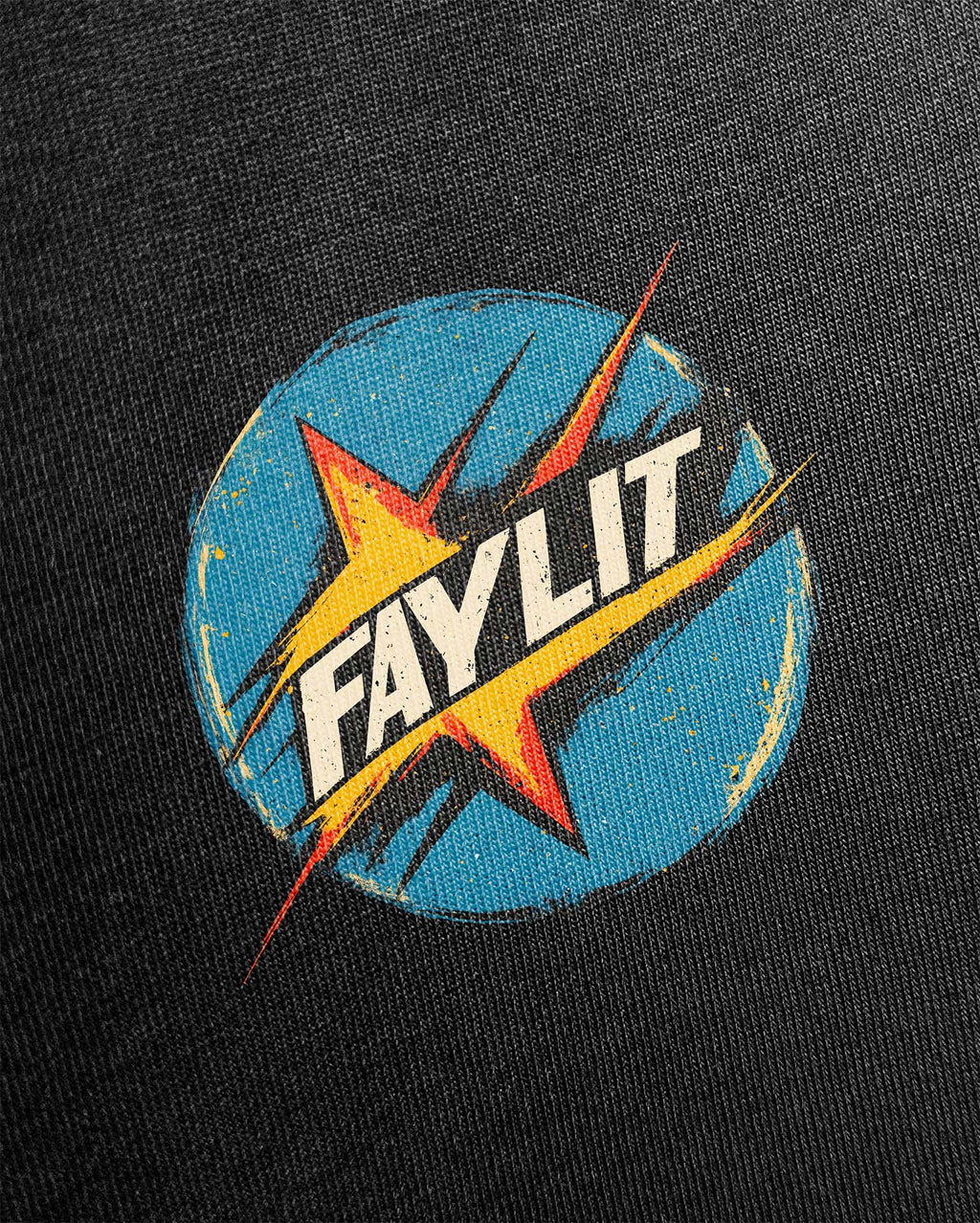 Lambo Premium Vintage Siyah Tişört - Siyah tişört üzerindeki dairesel logo baskısının detaylı yakın çekimi. Tasarım, retro çizgi roman ve pop-art estetiğine sahiptir. Mavi, eskitme dokulu bir dairenin içinde, patlama efektli sarı bir yıldız ve üzerinde beyaz "FAYLIT" yazısı yer alıyor. Baskının yıpranmış ve nostaljik görünümü dikkat çekiyor. -  Faylit