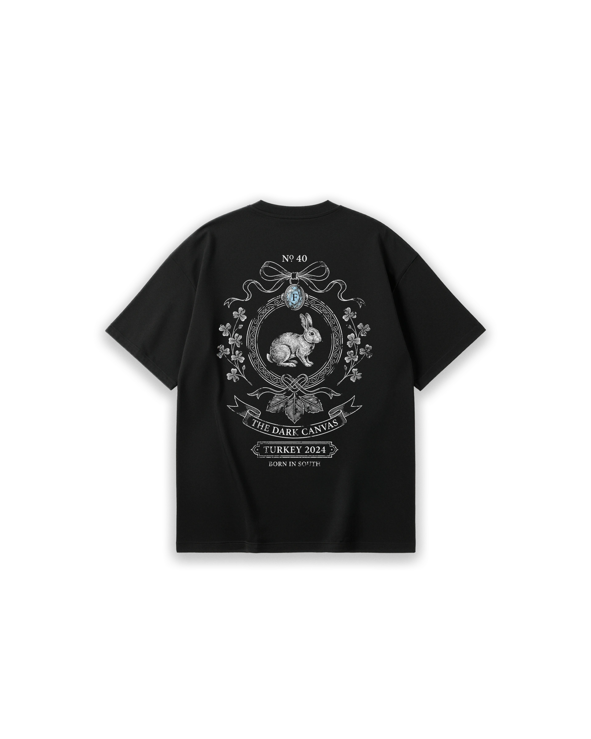 Faylit The Lucky Charm siyah oversized tişörtün arka yüzü. Sırtta şans getiren yonca yaprakları ve süslü bir çerçeve içine yerleştirilmiş detaylı tavşan illüstrasyonu (rabbit print). "The Dark Canvas" ve "Turkey 2024" yazılarıyla tamamlanmış, vintage ve gotik estetiğe sahip rahat kesim (loose fit) unisex siyah t-shirt tasarımı.