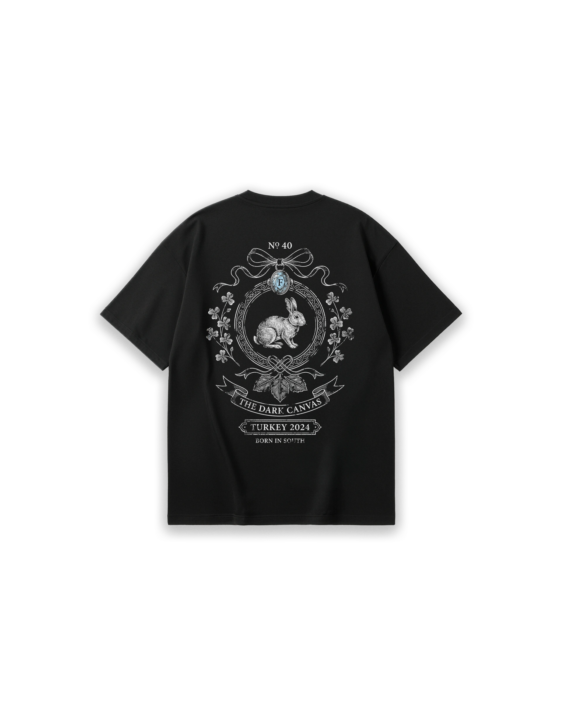 Faylit The Lucky Charm siyah oversized tişörtün arka yüzü. Sırtta şans getiren yonca yaprakları ve süslü bir çerçeve içine yerleştirilmiş detaylı tavşan illüstrasyonu (rabbit print). "The Dark Canvas" ve "Turkey 2024" yazılarıyla tamamlanmış, vintage ve gotik estetiğe sahip rahat kesim (loose fit) unisex siyah t-shirt tasarımı.