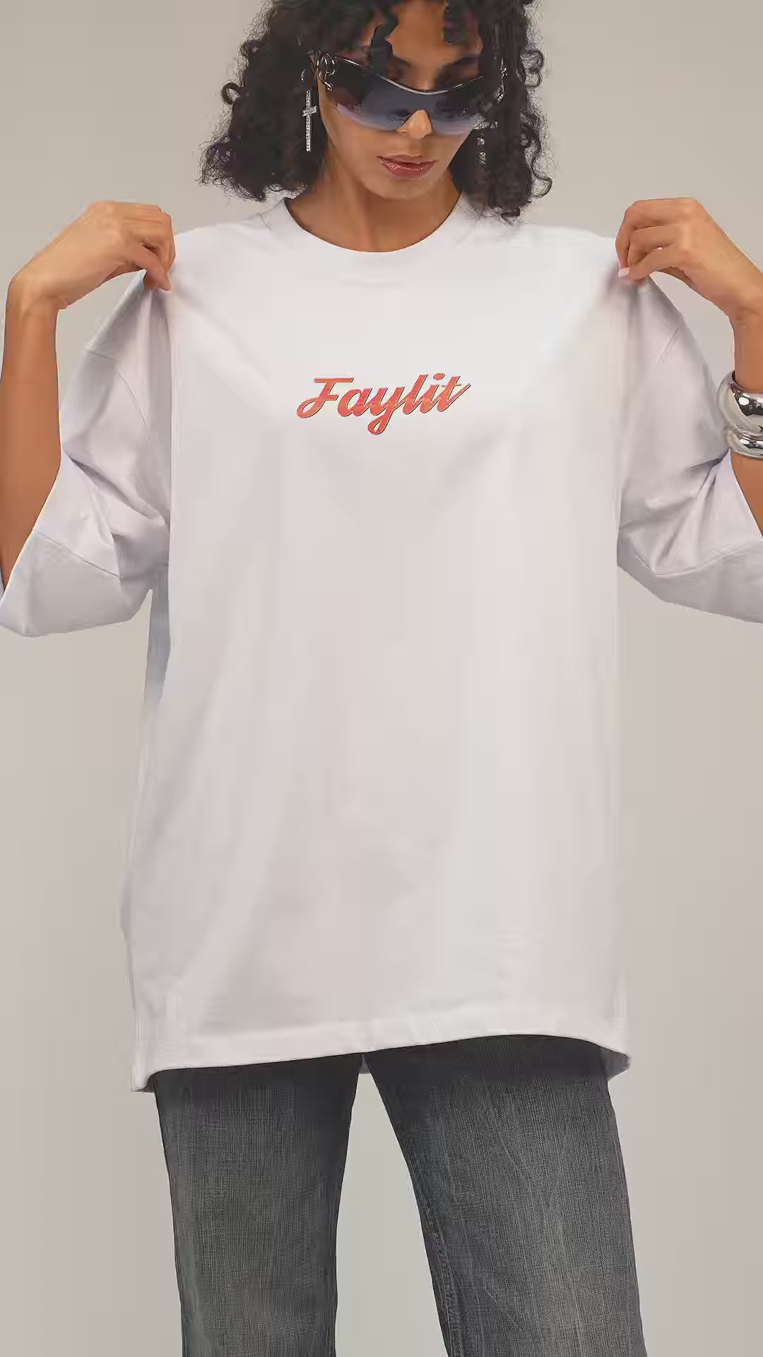 Faylit Abstract portrait grafik beyaz oversize tişört giyen retro kombinli kıvırcık saçlı manken. Manken ayrıca 90 lar modasına uygun büyük bir gözlük kullanıyor. mavinin retro tonları kullanılarak hazırlanmış tasarım nefes alabilen özelliği ön plana atılıyor