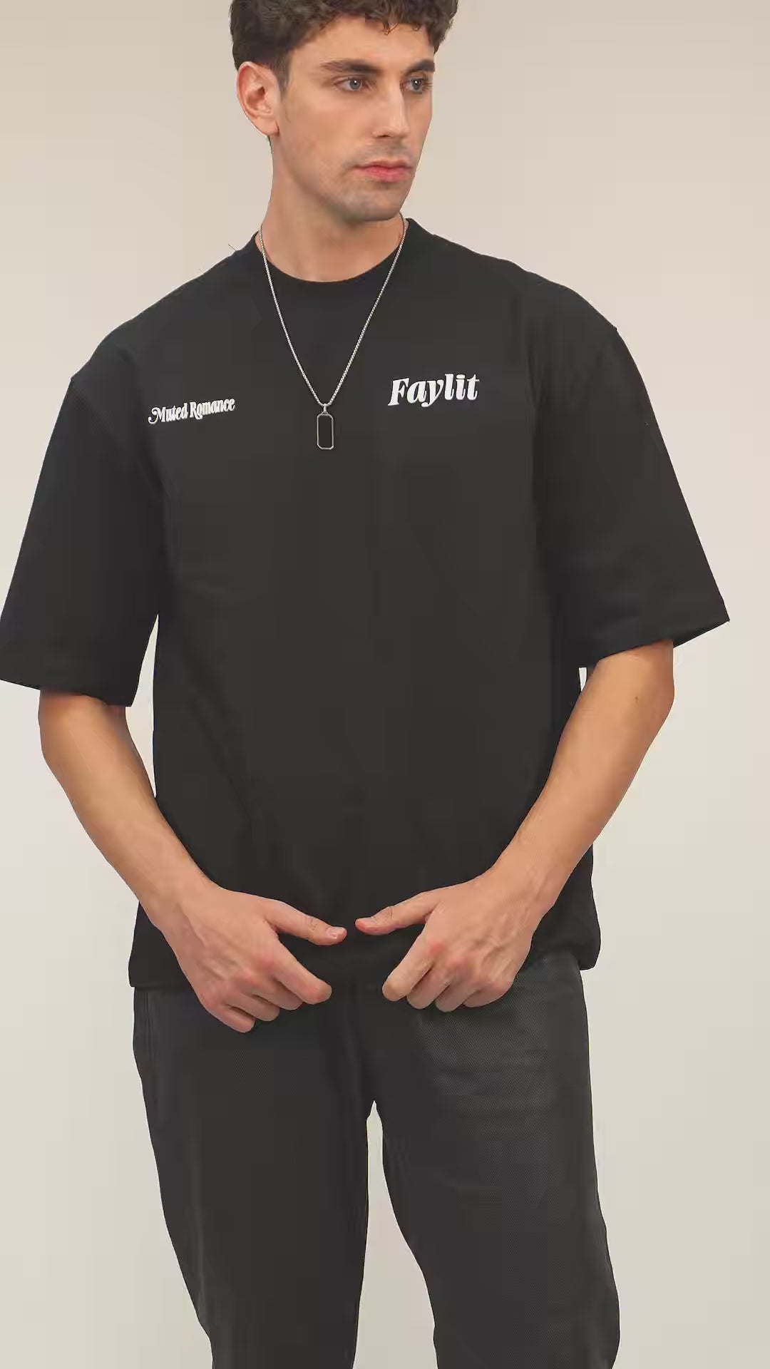 Faylit Siyah Upside Down oversize premium tişört giyen foto model balina kuyruğu tasarım bir kolye takıyor. Beyaz bir mendille tamamlanmış bu kombinin alt üst edilmiş tişört tasarımı ve baskısı oldukça dikkat çekici